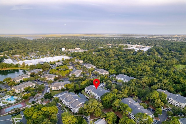 drone / aerial view featuring a forest view, a water view, and a residential view