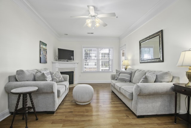 living area with ornamental molding and wood finished floors