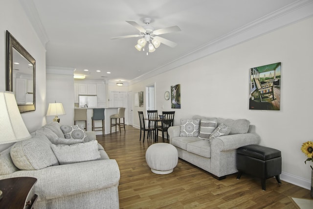 living room featuring crown molding, recessed lighting, a ceiling fan, wood finished floors, and baseboards