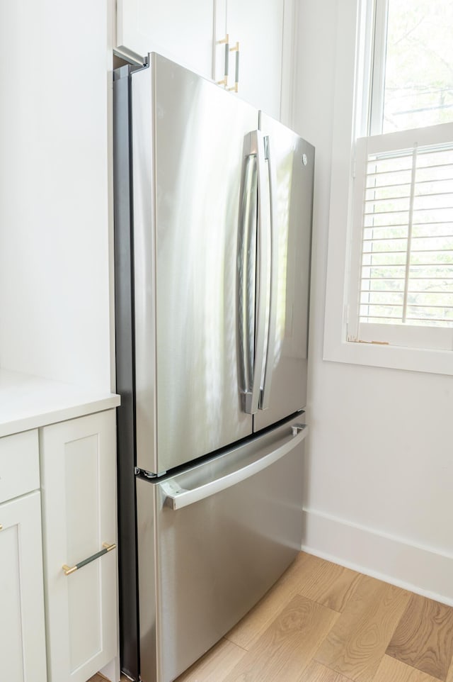173 Coming St Unit B, Charleston, SC 29403 - kitchen view of freestanding refrigerator, light wood-style flooring, white cabinets, and light countertops