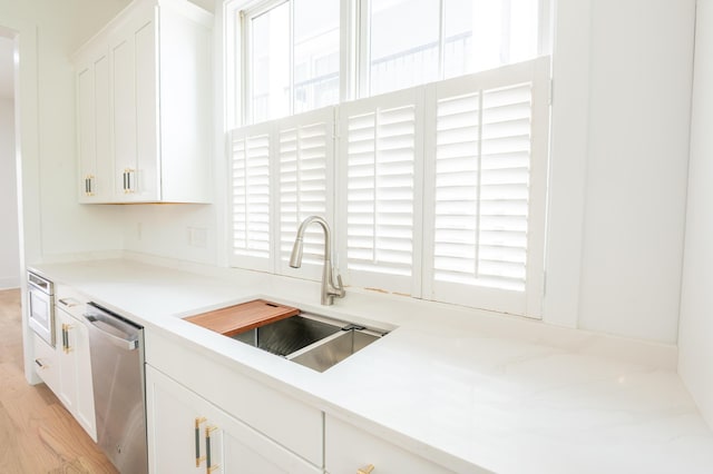 173 Coming St Unit B, Charleston, SC 29403 - kitchen with dishwasher, white cabinetry, light wood-style flooring, and light countertops