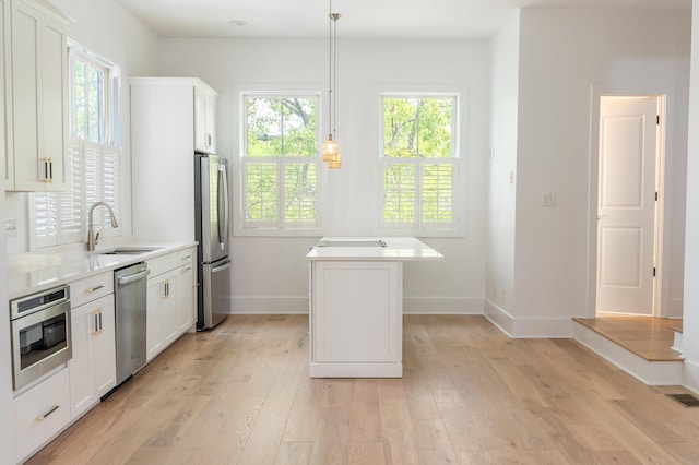 173 Coming St Unit B, Charleston, SC 29403 - kitchen with appliances with stainless steel finishes, a kitchen island, light wood-style flooring, and white cabinets