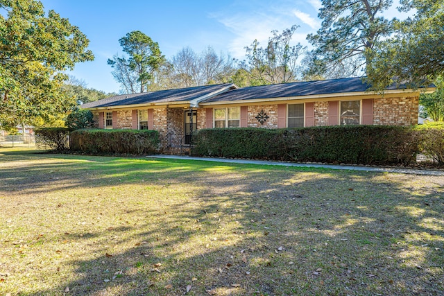 ranch-style home with a front yard and brick siding