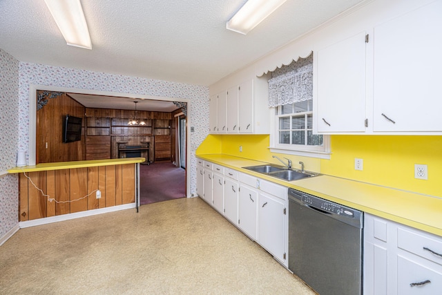 kitchen with a sink, white cabinets, black dishwasher, light countertops, and wallpapered walls