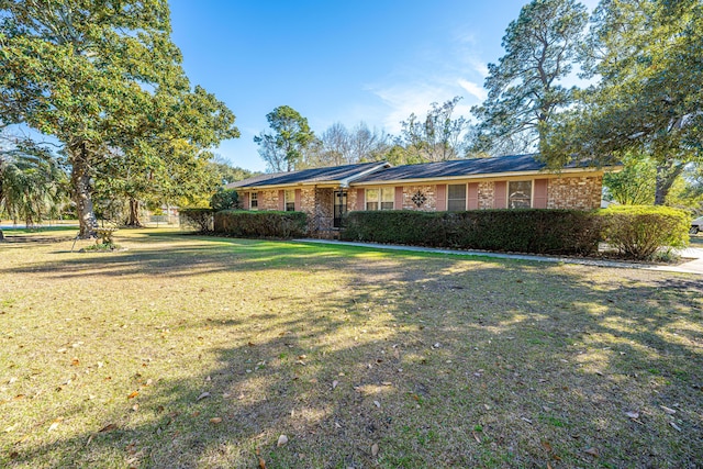 ranch-style house with brick siding and a front yard