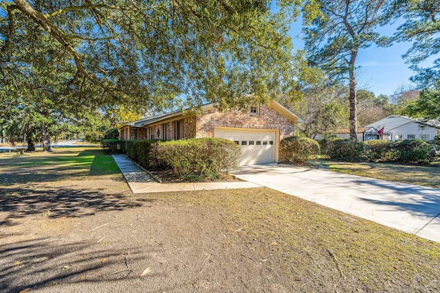 view of front facade featuring an attached garage, driveway, a front lawn, and brick siding