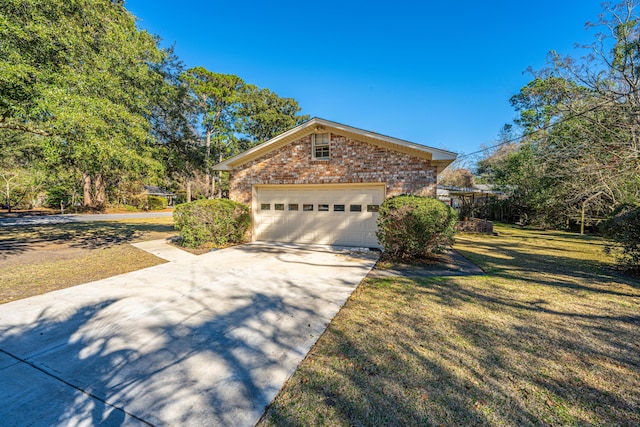 view of front of home with brick siding, concrete driveway, a front yard, a garage, and an outdoor structure