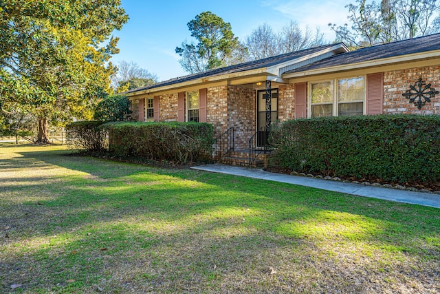 single story home featuring brick siding and a front lawn