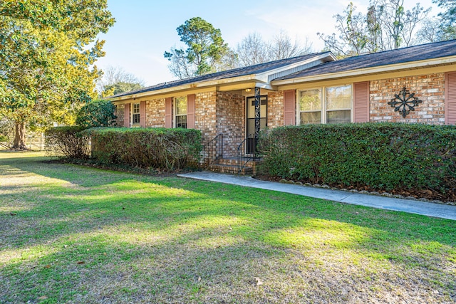 single story home with a front lawn and brick siding