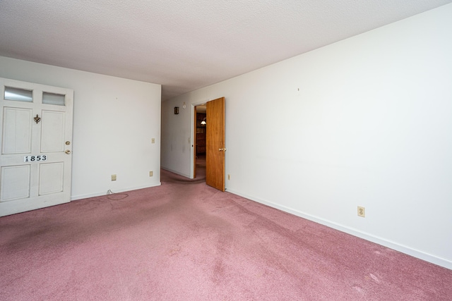 carpeted spare room featuring baseboards and a textured ceiling