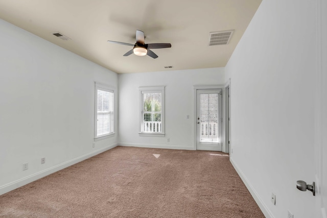 unfurnished room with visible vents, ceiling fan, baseboards, and carpet