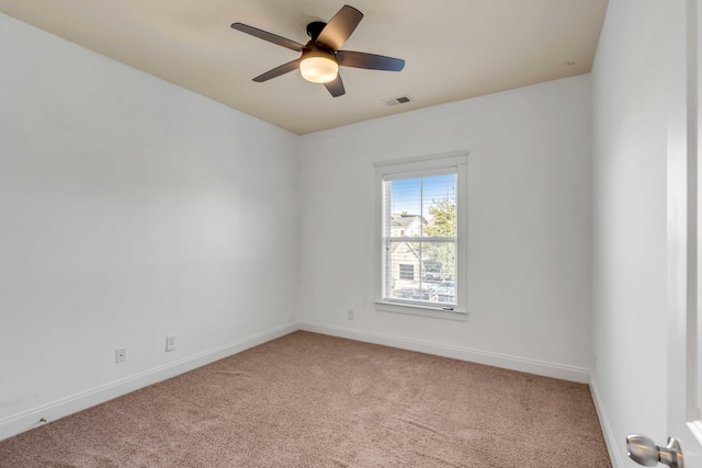 carpeted empty room featuring visible vents, baseboards, and a ceiling fan