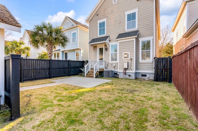 rear view of house with a gate, central AC unit, a fenced backyard, a patio area, and a lawn