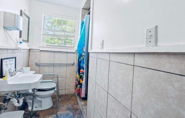 bathroom with sink, tile walls, and toilet