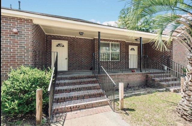 view of exterior entry featuring covered porch