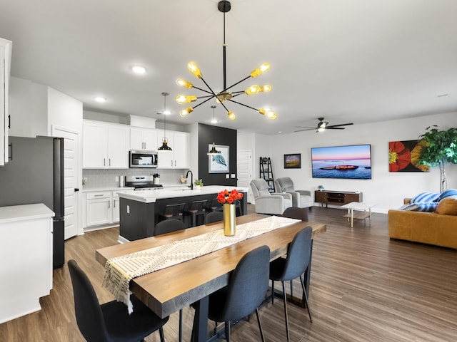 dining area with recessed lighting, ceiling fan with notable chandelier, and wood finished floors