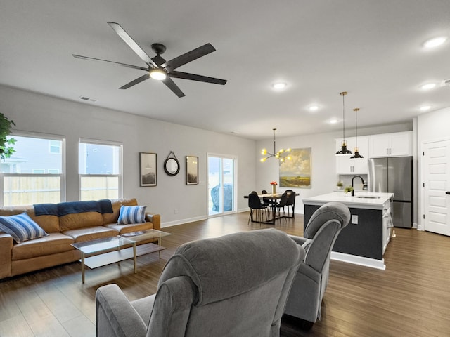 living room with recessed lighting, visible vents, dark wood finished floors, and ceiling fan with notable chandelier