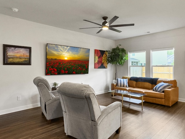 living area with dark wood-style flooring, baseboards, visible vents, and ceiling fan