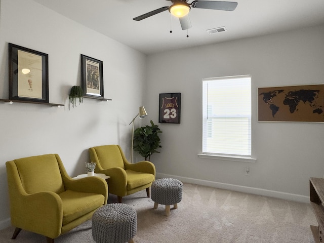 sitting room featuring baseboards, visible vents, ceiling fan, and carpet
