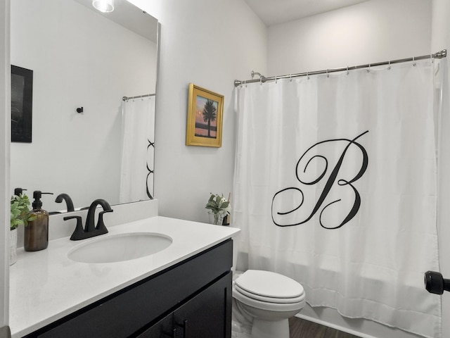 full bath with vanity, shower / bath combo with shower curtain, toilet, and wood finished floors