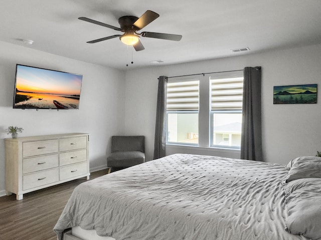 bedroom with baseboards, ceiling fan, dark wood-style floors, and visible vents