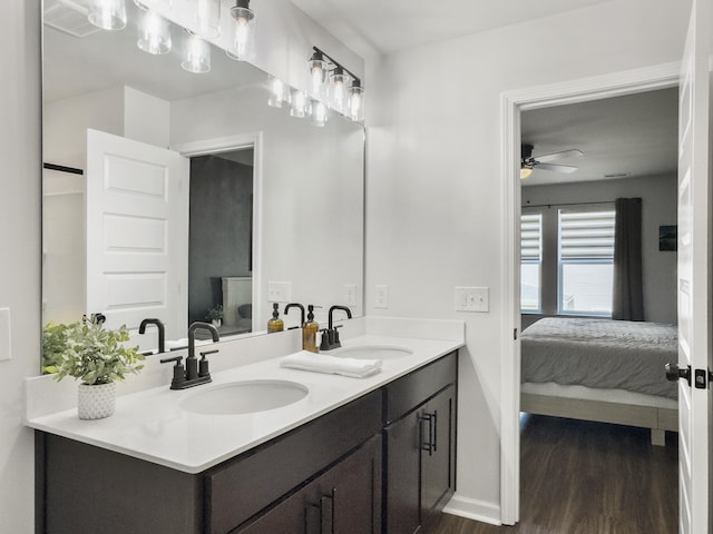 ensuite bathroom featuring a sink, ensuite bathroom, ceiling fan, and wood finished floors