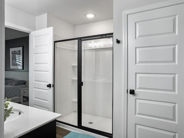 bathroom with vanity, wood finished floors, and a stall shower