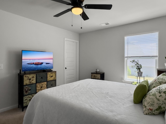 carpeted bedroom with a ceiling fan, baseboards, and visible vents