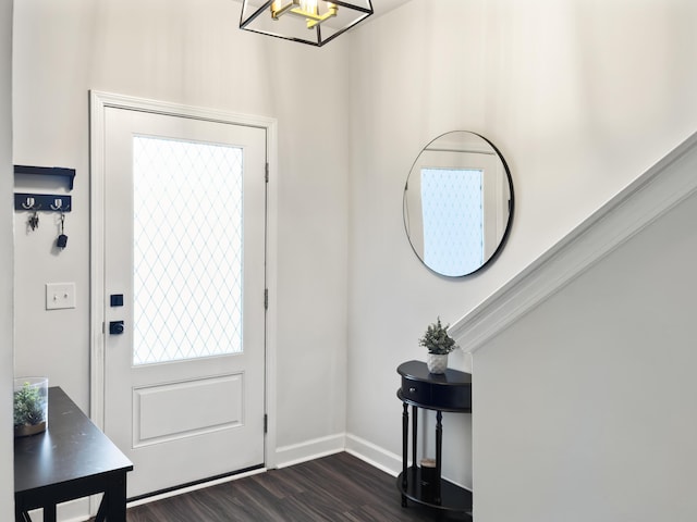 entryway featuring an inviting chandelier, baseboards, and dark wood-style floors