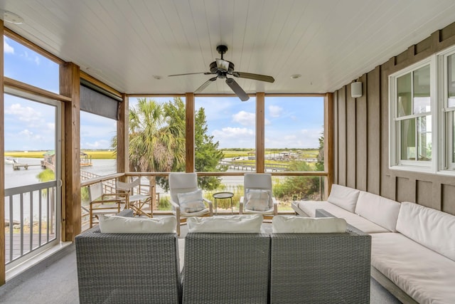 sunroom / solarium with ceiling fan, a healthy amount of sunlight, and a water view