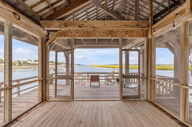 unfurnished sunroom with a water view, a healthy amount of sunlight, and vaulted ceiling