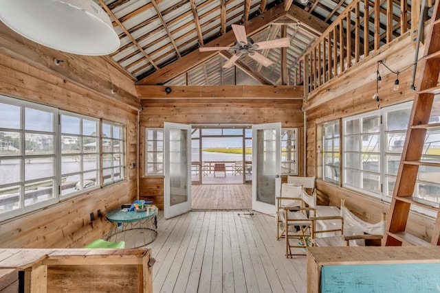 sunroom / solarium with ceiling fan, a water view, and vaulted ceiling