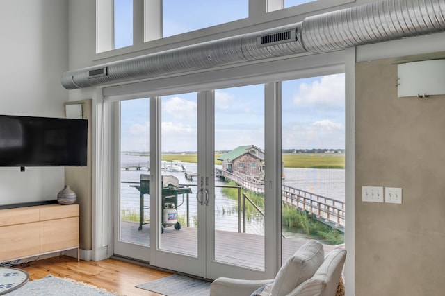 doorway to outside featuring hardwood / wood-style floors and a water view