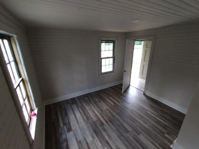 unfurnished room with wood walls, wood ceiling, and dark wood-type flooring