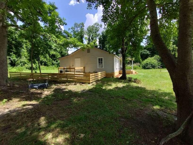 view of side of home featuring a wooden deck and a yard