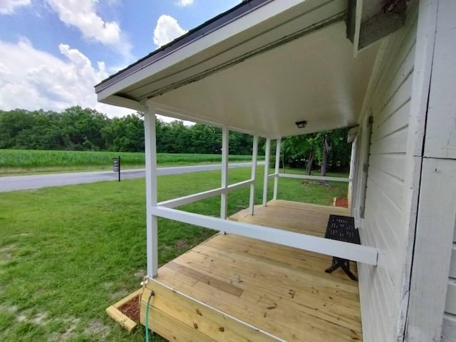 wooden terrace featuring a yard