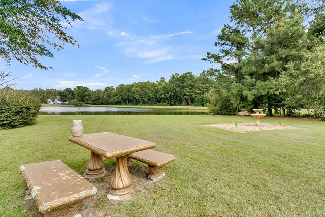 view of home's community featuring a water view and a yard