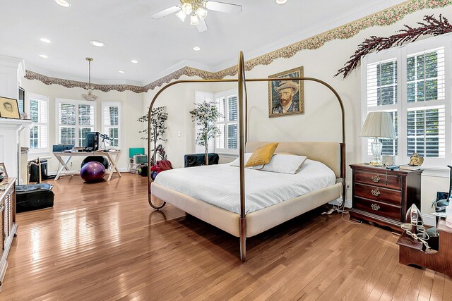 bedroom featuring light hardwood / wood-style flooring, ornamental molding, multiple windows, and ceiling fan