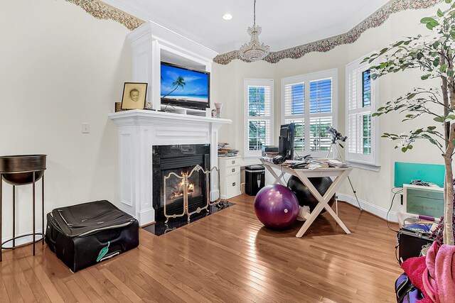 office space featuring ornamental molding, baseboards, a chandelier, light wood-style floors, and a high end fireplace