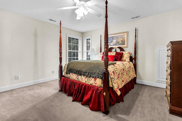 carpeted bedroom with ceiling fan and a textured ceiling