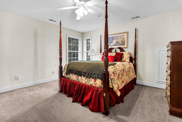 bedroom with visible vents, carpet flooring, and a textured ceiling