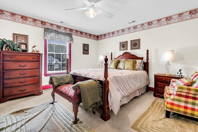 bedroom with baseboards, ceiling fan, visible vents, and light colored carpet