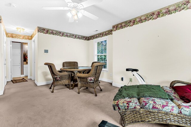 carpeted dining space featuring baseboards and ceiling fan