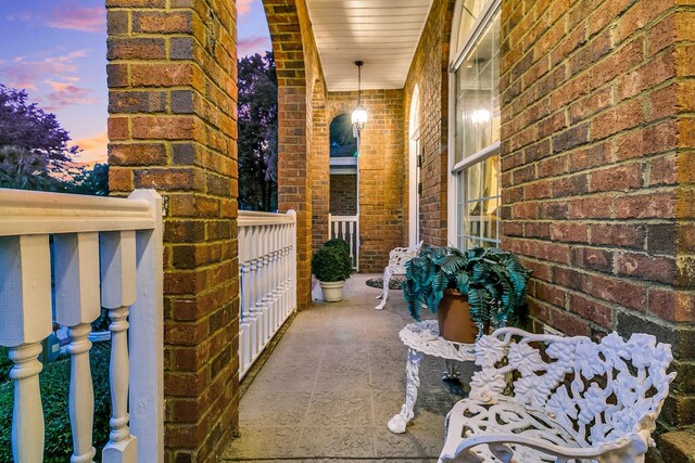 exterior space featuring covered porch and brick siding