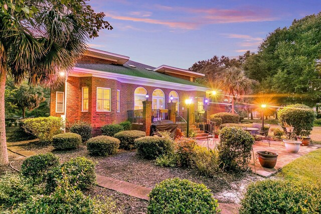 view of front of house with brick siding and a patio area