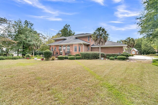 view of front of home with brick siding and a front yard