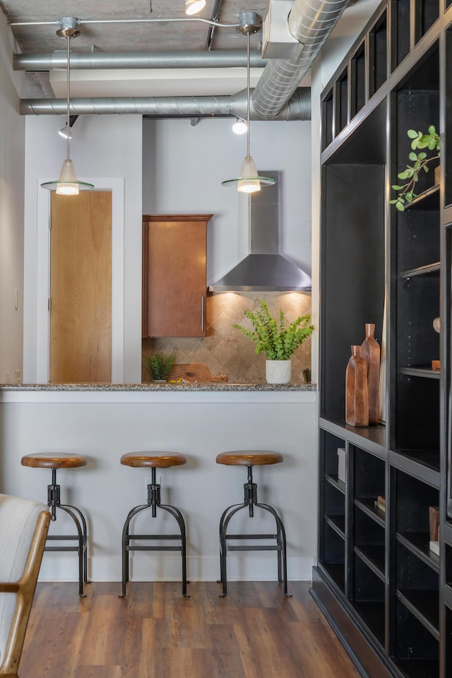150 Bee St Unit 308, Charleston, SC 29401 - kitchen featuring wall chimney exhaust hood, decorative backsplash, dark wood-type flooring, and pendant lighting