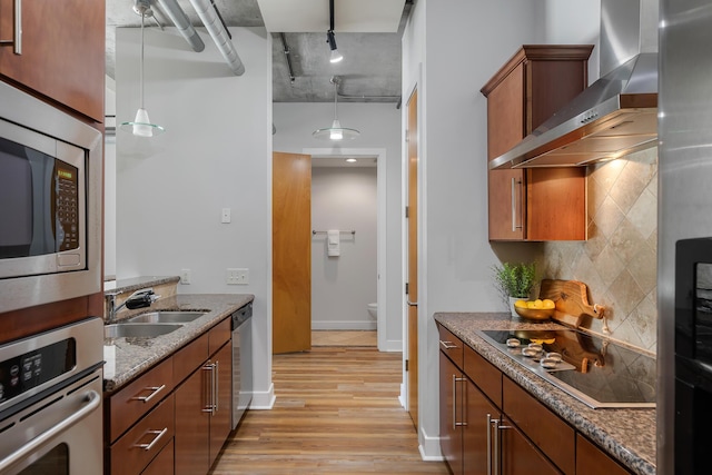 150 Bee St Unit 308, Charleston, SC 29401 - kitchen featuring wall chimney exhaust hood, appliances with stainless steel finishes, light wood-type flooring, backsplash, and stone countertops