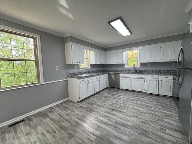 kitchen featuring stainless steel dishwasher, a sink, white cabinets, crown molding, and wood finished floors