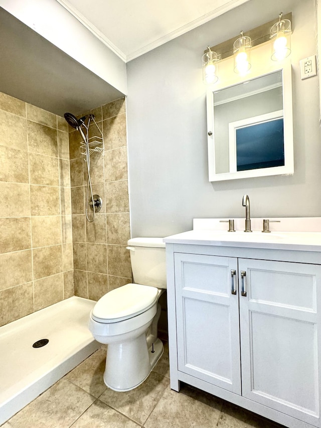bathroom featuring crown molding, vanity, toilet, a tile shower, and tile patterned flooring